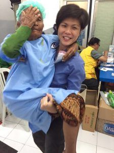 Siew Yian carrying a patient to the surgery waiting room